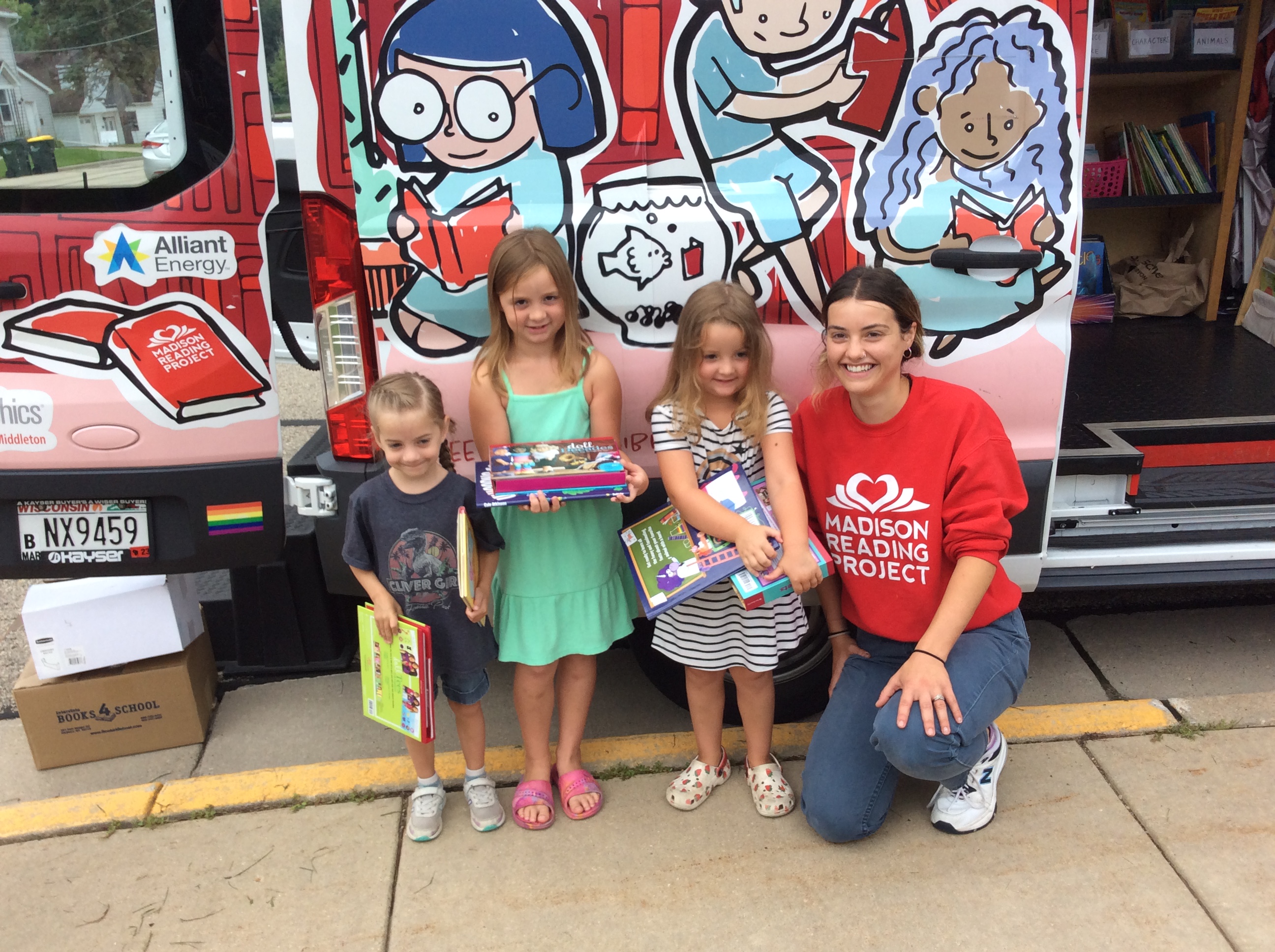 Madison Reading Project staff and children stand in front of Big Red Bus.