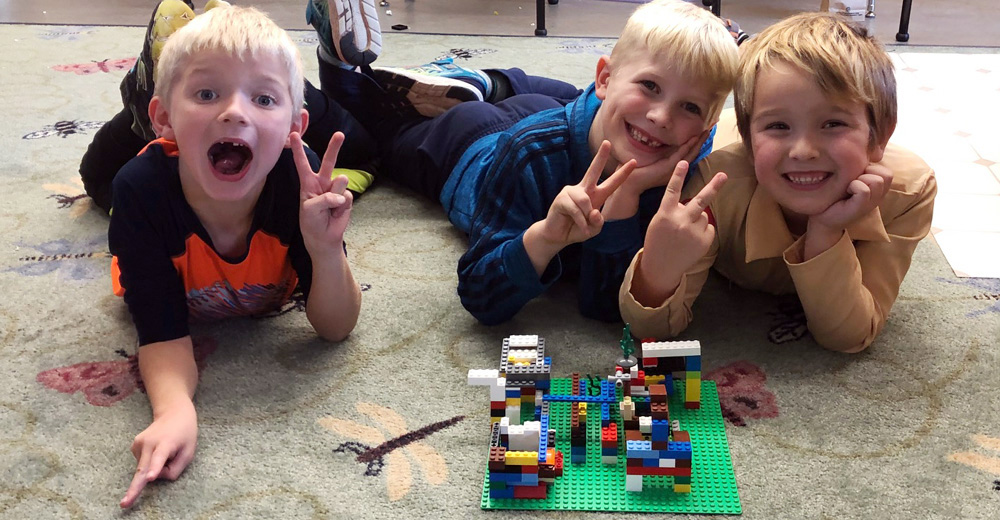 Three boys with their Lego creation.