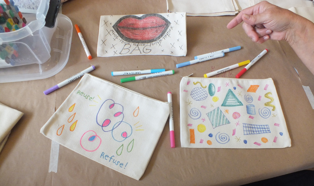 3 cloth bags with colorful drawings and markers.