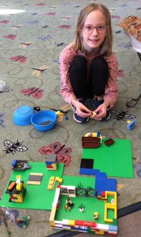 Maggie Builds Girl building with legos