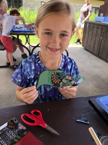 Gretta with bird Girl holding paper bird creation.