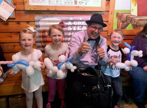 Neil and Kids Neil the balloon twister with 3 kids and their balloon animals
