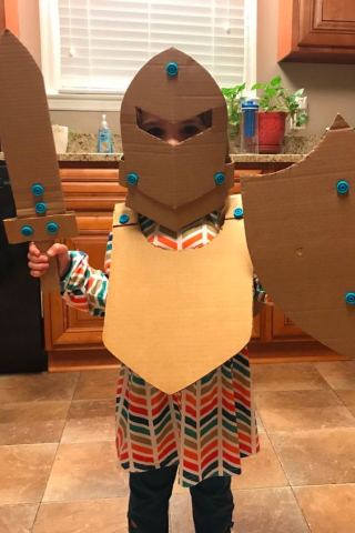 small child in cardboard knight costume