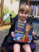 Little girl in rocking chair holding book