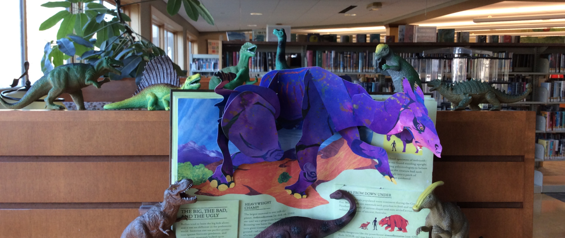 Pop-up book with toy dinosaurs